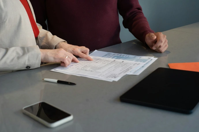 Two people reviewing documents at a table.